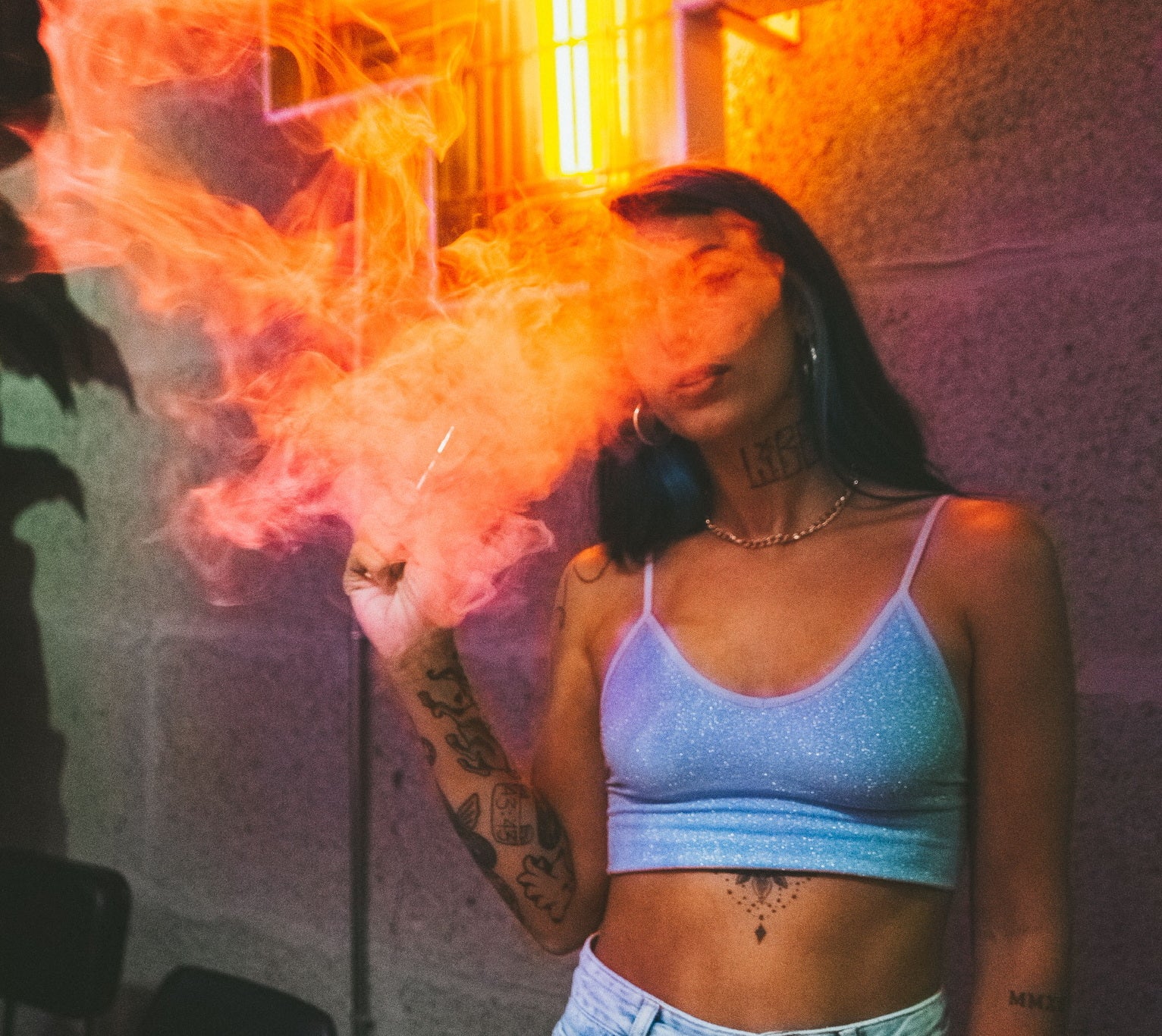 woman smoking weed joint in a cannabis club in front of orange sign